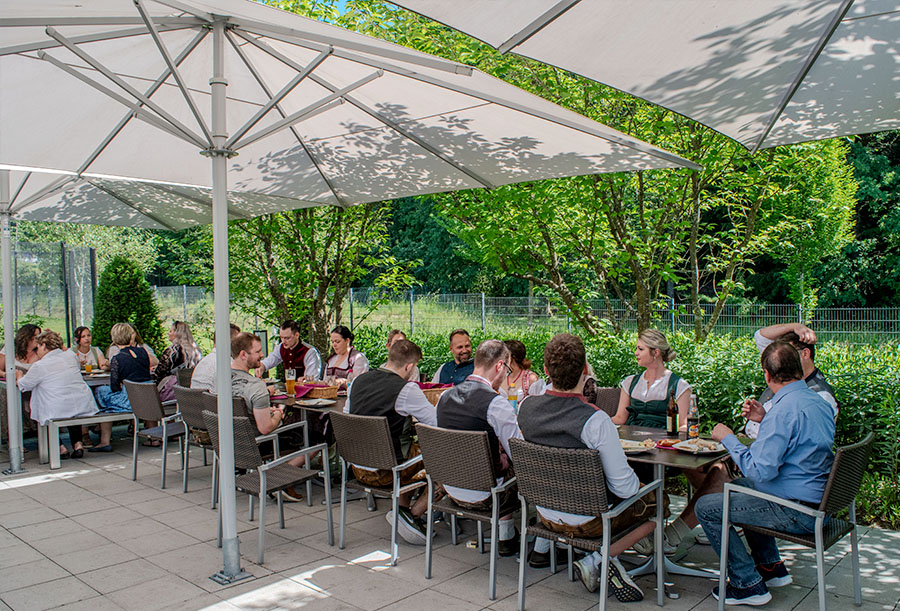 Alle MEGATECH Mitarbeiter sitzen auf der idyllischen Firmenterrasse
