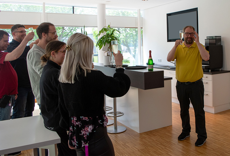 Mitarbeiter stoßen auf den runden Geburtstag an