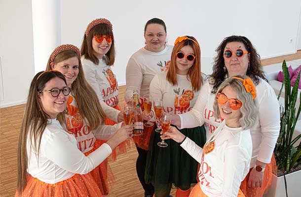 Die kostümierten Frauen stoßen mit Sektgläsern auf das Faschingstreiben an