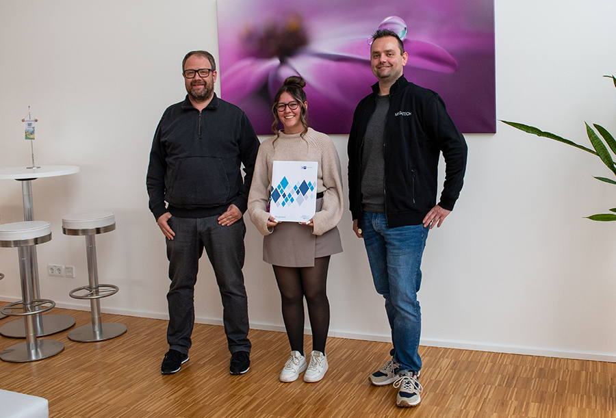 Anna mit ihrem Ausbildungszeugnis und ihren Vorgesetzten