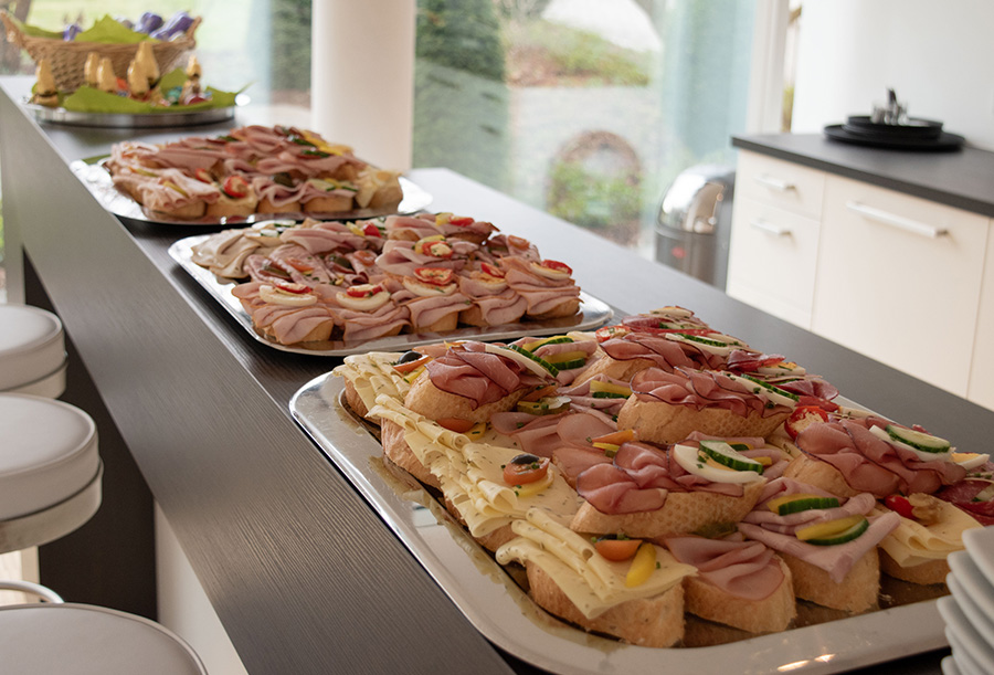 Mehrere Silbertabletts mit belegten Brötchen