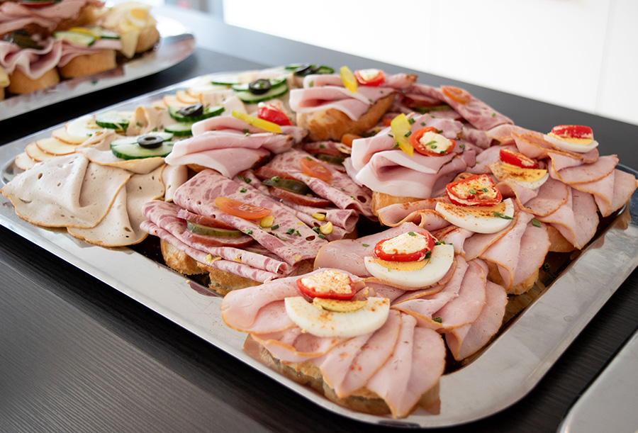 Üppig belegte Brötchen mit Wurst, Ei und Gemüse