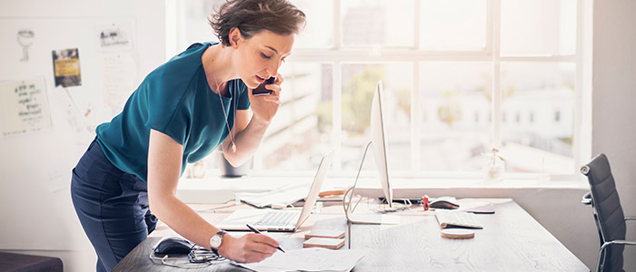 Home-Office Mitarbeiterin am Schreibtisch beim Telefonieren