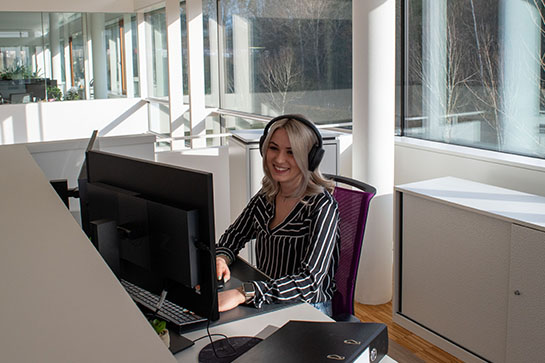 Selina an ihrem modernen Arbeitsplatz am Empfang